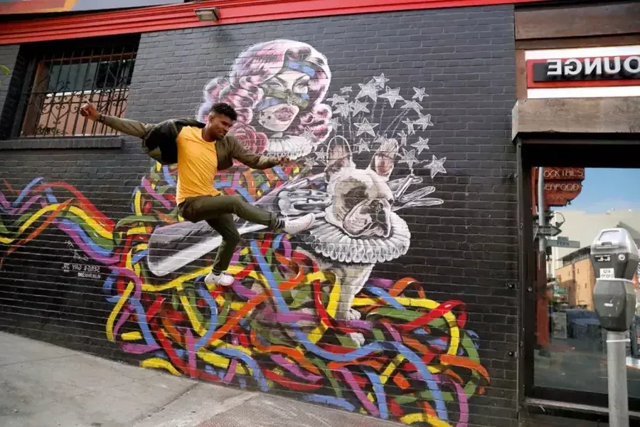 Artist Serge Gay Jr. in front of one of his many murals.